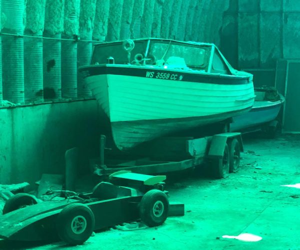 A boat on a trailer inside a garage.