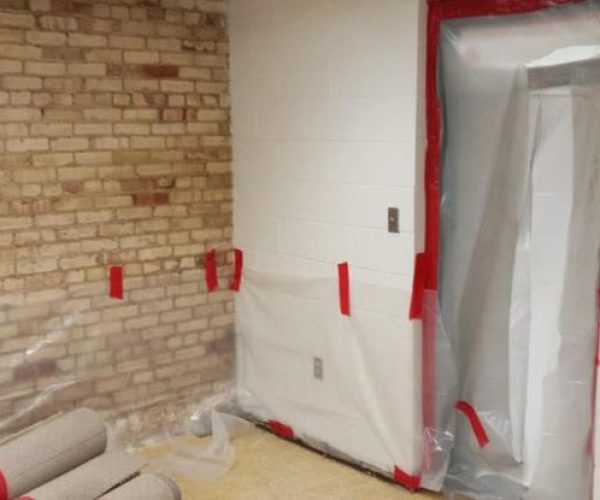 Brick wall room with door protected by plastic covering.